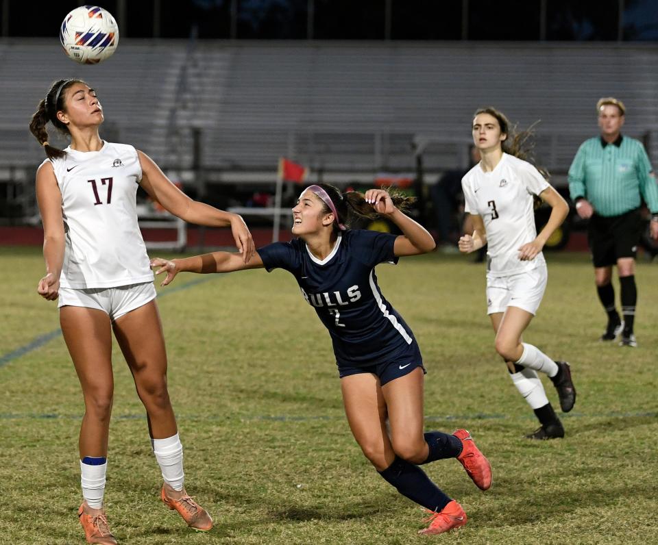 Braden River's Giselle Bostock (#17) heading the ball as Parrish's Vanessa Marasco (#2) looks on during the Class 5A-Region 3 match. The Parrish Bull's won 4-2 over the visiting Braden River Pirates on Tuesday.