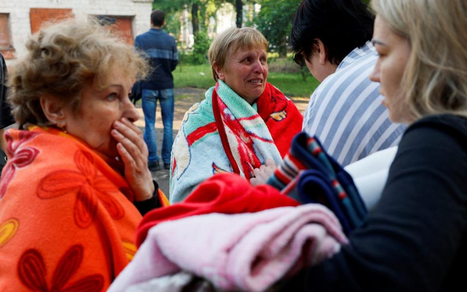 People outside a residential building heavily damaged by a Russian missile strike in Kryvyi Rih, Dnipropetrovsk region - ALINA SMUTKO/REUTERS