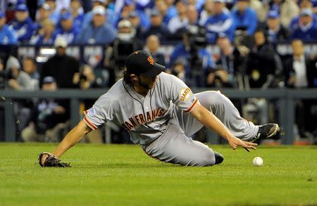 Oct 21, 2014; Kansas City, MO, USA; San Francisco Giants starting pitcher Madison Bumgarner slides to field a ball hit by Kansas City Royals first baseman Eric Hosmer (not pictured) in the 6th inning during game one of the 2014 World Series at Kauffman Stadium. John Rieger-USA TODAY Sports