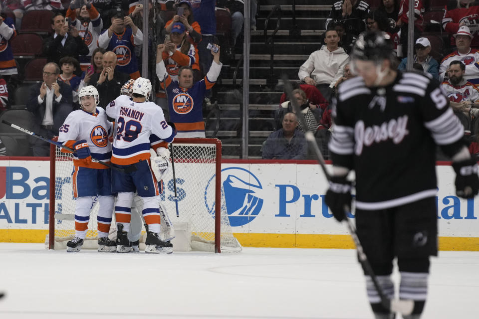 New York Islanders' Sebastian Aho, left, Alexander Romanov, second from front left, and goaltender Semyon Varlamov, back left, celebrate after an NHL hockey game against the New Jersey Devils in Newark, N.J., Monday, April 15, 2024. (AP Photo/Seth Wenig)