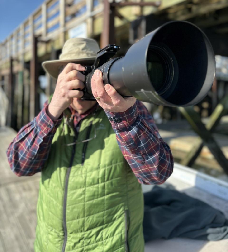 Local photographer Jack Coughlin snaps pictures of loons as they wade across the water at the harbor in Wells, Maine, on April 15, 2024.