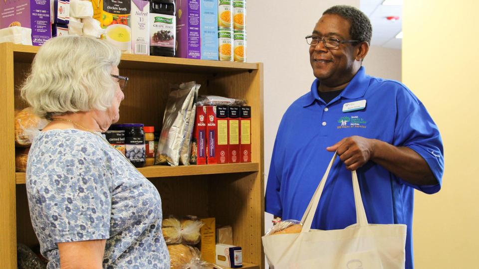 At the Max Block Food Pantry, a woman receives much-needed groceries. The pantry is run by The LJD Jewish Family & Community Services in Jacksonville.