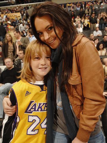 <p>Andrew D. Bernstein/NBAE/Getty </p> Lindsay Lohan poses with brother Dakota during halftime of the Los Angeles Lakers versus the Atlanta Hawks on December 8, 2006 in Los Angeles, California