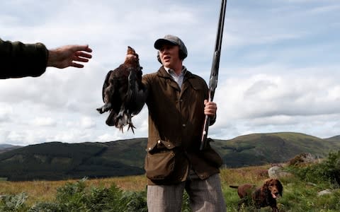 A member of a shooting party holds a hunted grouse on the Rottal Moor on the opening day of the Grouse shooting season on Monday - Credit: RUSSELL CHEYNE&nbsp;/REUTERS