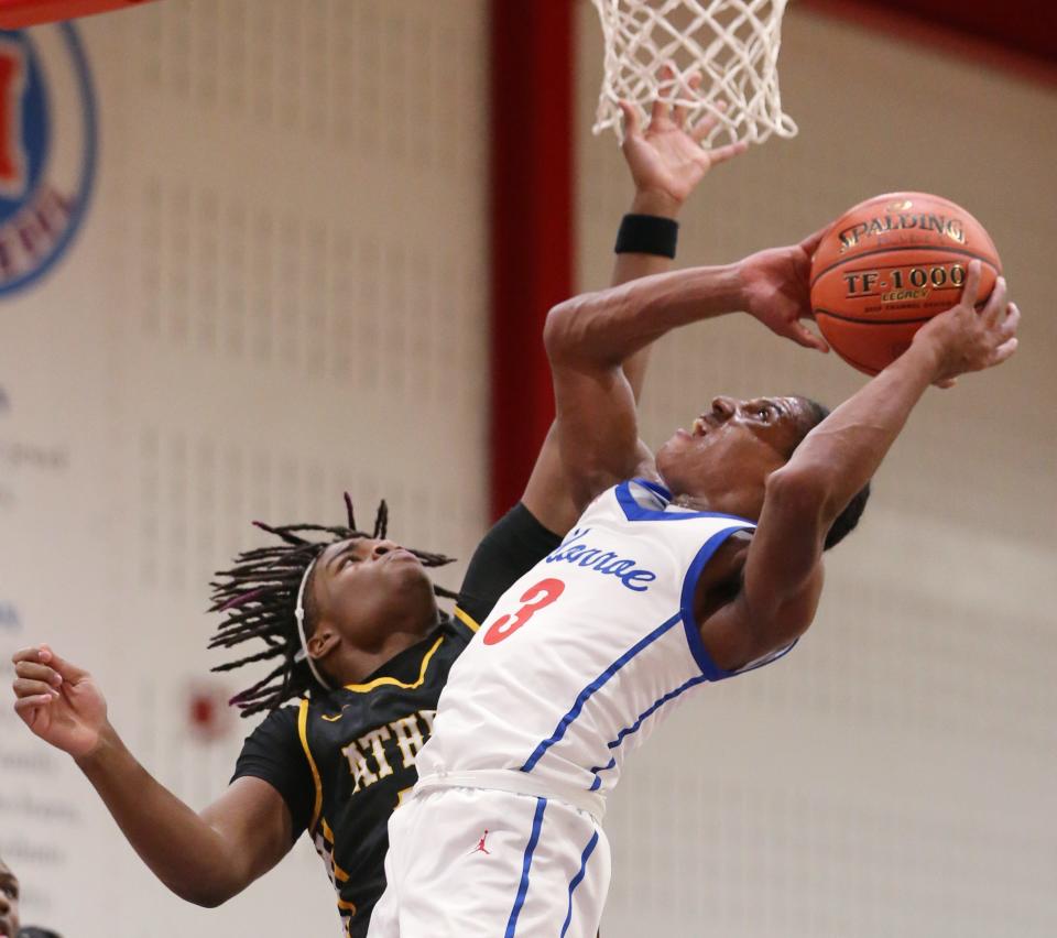 Monroe's William McKinney draws the foul on Athena's Byron Williams as he gets to the rim on a second quarter drive.