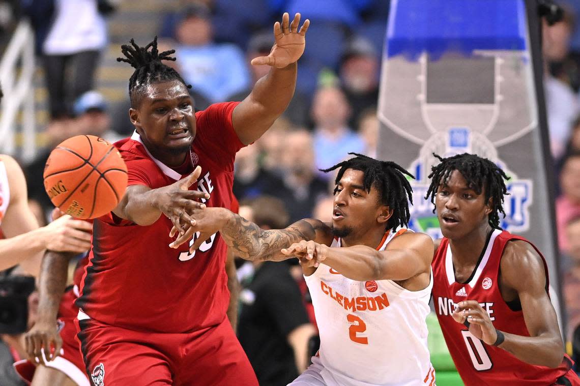 Clemson guard Dillon Hunter (2) passes the ball as NC State Wolfpack forward D.J. Burns Jr. (30) and guard Terquavion Smith (0) defend Thursday at the ACC tournament.