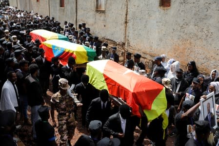Mourners carry the coffin of Amhara president Mekonnen and two other officials during their funeral in the town of Bahir Dar