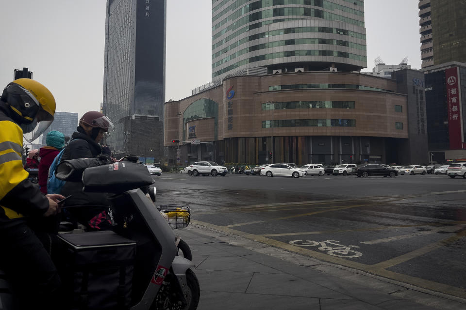 Motorists move past Sichuan Trust office building in Chengdu in southwestern China's Sichuan Province on Feb. 27, 2024. Some investors in a troubled trust fund in China are facing financial ruin under a government plan to return a fraction of their money, casualties of a slump in the property industry and a broader economic slowdown. (AP Photo/Andy Wong)