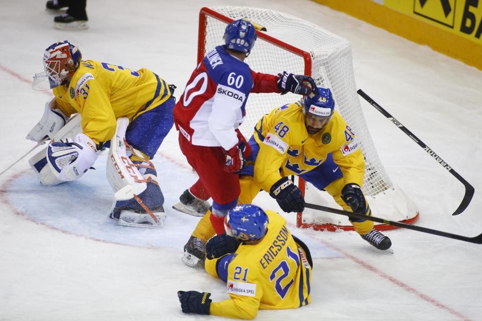 Sweden's Anders Nilsson, left, Jimmie Ericsson, foreground center, Daniel Rahimi and Czech Republic's Tomas Rolinek battle for the puck during the Group A preliminary round match at the Ice Hockey World Championship in Minsk, Belarus, Sunday, May 11, 2014. (AP Photo/Sergei Grits)