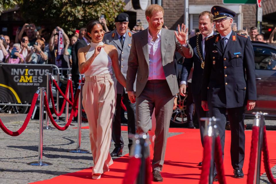 06 September 2022, North Rhine-Westphalia, Duesseldorf: Britain's Prince Harry (3rd from right, Duke of Sussex, and his wife Meghan (l), Duchess of Sussex, arrive in front of City Hall and walk a red carpet alongside Alfred Marstaller (r), Brigadier General, and Stephan Keller (CDU, 2nd from right,), Lord Mayor of the state capital Düsseldorf. The prince and his wife are coming to Düsseldorf to promote the "Invictus Games" 2023, which Prince Harry helped launch. These are Paralympic competitions for soldiers injured in war. Photo: Rolf Vennenbernd/dpa (Photo by Rolf Vennenbernd/picture alliance via Getty Images)