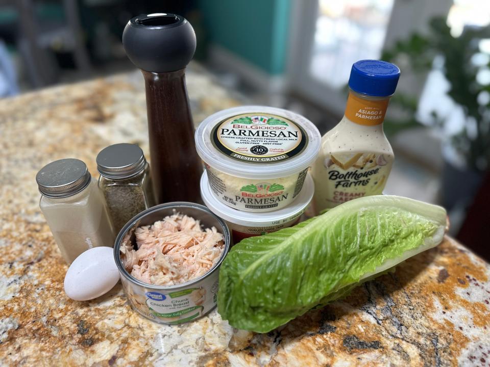 Canned chicken, lettuce, grated parm, Caesar dressing, an egg, salt and pepper on counter