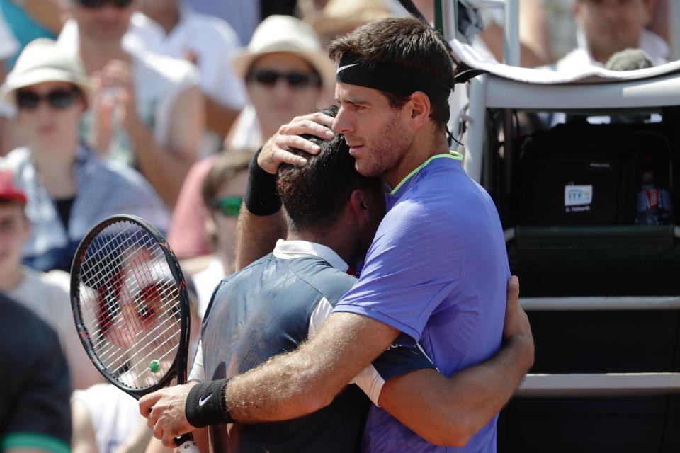 Spain's Nicol&aacute;s Almagro, left, is comforted by Argentina's Juan Mart&iacute;n del Potro as a knee injury forces him to pull out of&nbsp;their tennis match&nbsp;at the French Open in Paris on Thursday. (Photo: THOMAS SAMSON via Getty Images)