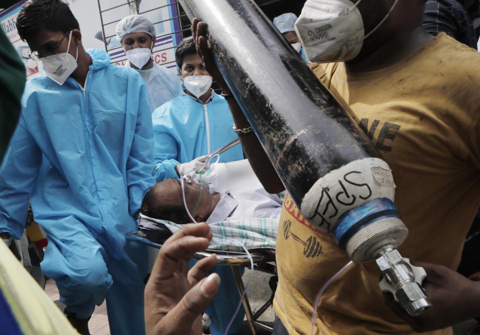 FILE - In this April 23, 2021, file photo, Health workers carry a patient after a fire in Vijay Vallabh COVID-19 hospital at Virar, near Mumbai, India. India is battling the world’s fastest pace of spreading infections. Its government has blocked vaccine exports for several months to better meet needs at home, exacerbating the difficulty of poor countries to access vaccine. (AP Photo/Rajanish Kakade, File)