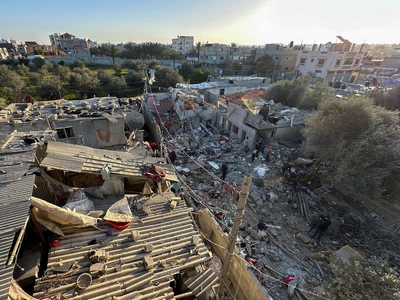 Palestinos en el lugar de un ataque israelí contra una casa, en medio del actual conflicto entre Israel y el grupo islamista palestino Hamás, en Ráfah, en el sur de la Franja de Gaza