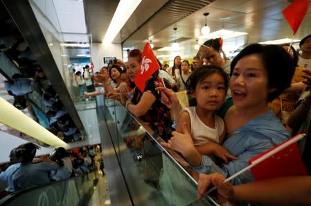 Pro-China demonstrators cheer as police officers detain anti-government protesters at Amoy Plaza shopping mall in Kowloon Bay, Hong Kong