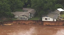 This image taken from video provided by KOCO-5 shows homes dangerously close to the Cimarron River on Wednesday, May 22, 2019 near Crescent, Oka. Waterlogged parts of the central U.S. were bracing Wednesday for more rain, following days of severe storms that have battered Iowa, Kansas, Missouri and Oklahoma. (KOCO-5 via AP)