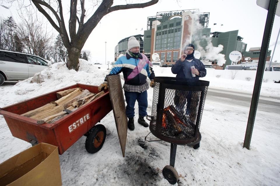 Green Bay Packers fans gather around the fire as they tailgate before an NFL wild-card playoff football game between the Green Bay Packers and the San Francisco 49ers, Sunday, Jan. 5, 2014, in Green Bay, Wis. (AP Photo/Jeffrey Phelps)