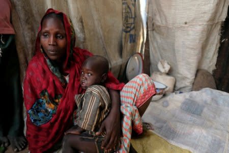 FILE PHOTO: Falmata Alwana, an internally displaced person living in Bama camp, Nigeria, poses for a picture with one of her children in her shelter November 23, 2017.  Picture taken November 23, 2017.  REUTERS/Paul Carsten/File Photo