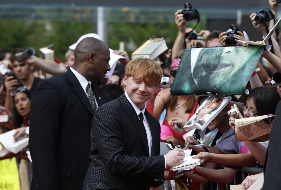 Cast member Rupert Grint signs autographs as he arrives for the premiere of the film "Harry Potter and the Deathly Hallows: Part 2" in New York July 11, 2011.  REUTERS/Lucas Jackson (UNITED STATES - Tags: ENTERTAINMENT)