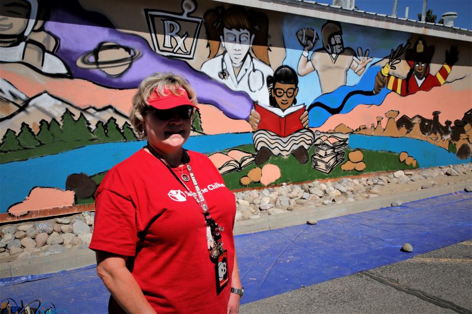 Blanco Elementary School Principal Lynda Spencer discusses some of the elements included in a community mural that was painted by summer school students on Thursday, June 29 at the Kare Drug location in Bloomfield.