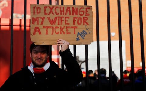 A fan outside Anfield before the game - Credit: Reuters