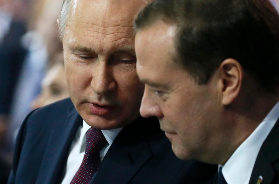 Russian President Vladimir Putin speaks to then-Prime Minister Dmitry Medvedev during the United Russia party congress in Moscow, Russia, in December 2017.