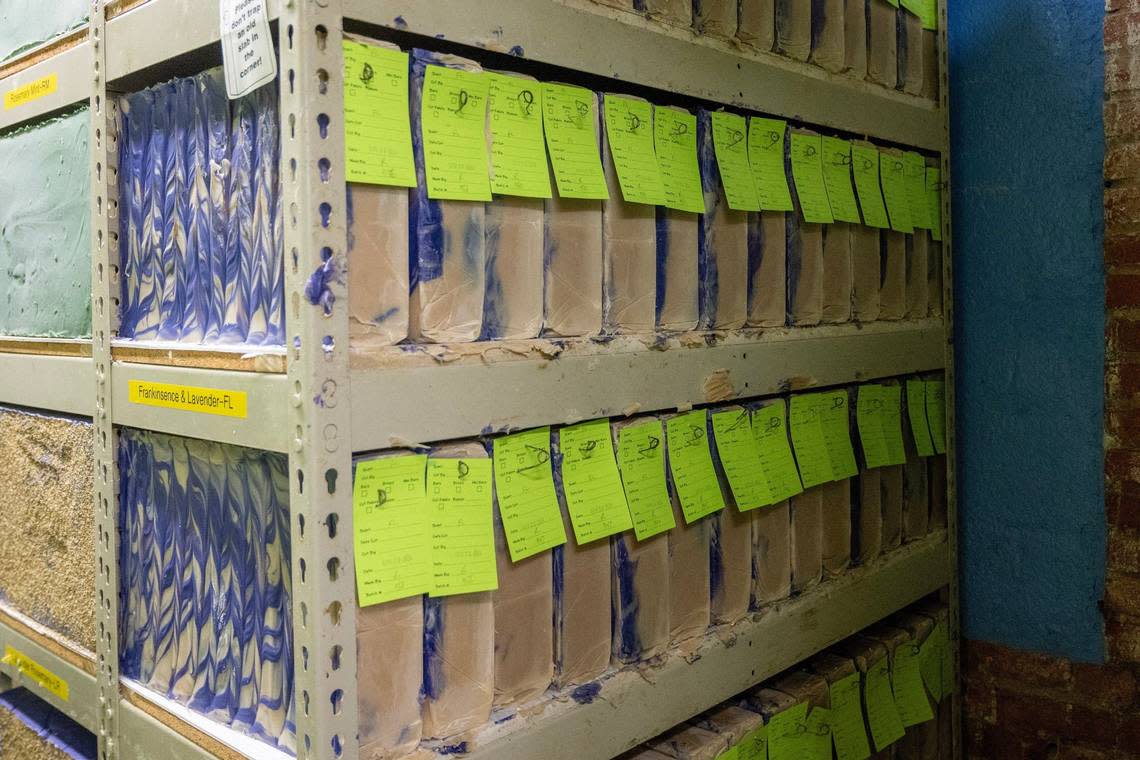 Slabs of frankincense-lavender Zum Bar soap are labeled and arranged on shelves to dry after they solidified in the forms.