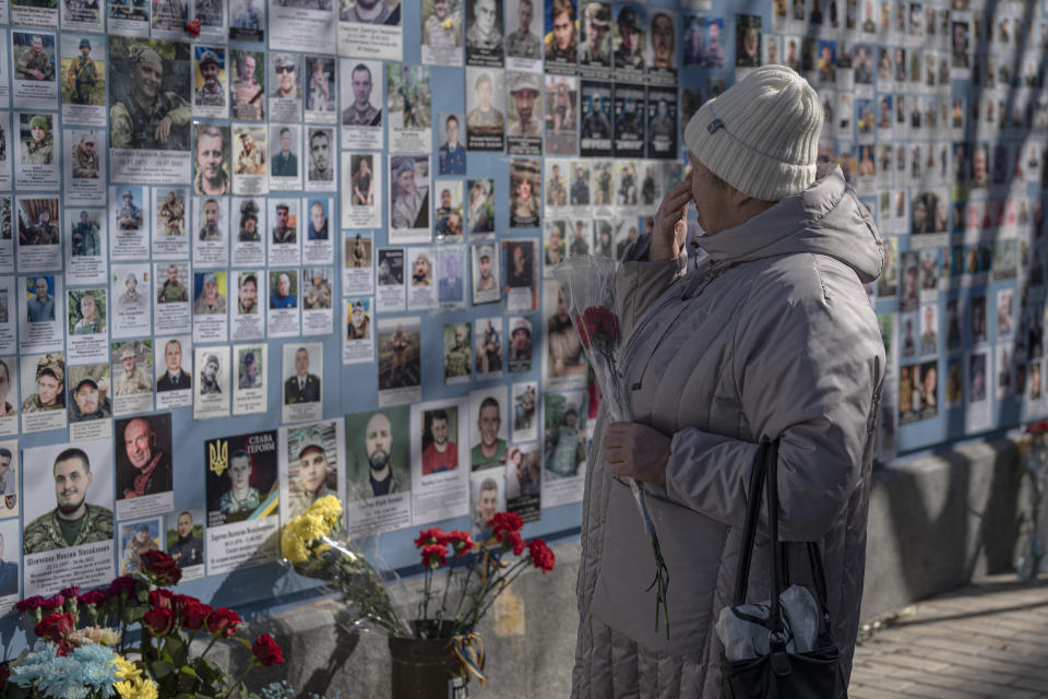 A woman watches the Memory Wall of Fallen Defenders of Ukraine in Russian-Ukrainian War, on Ukrainian Volunteer Day in Kyiv, Ukraine, Tuesday, March 14, 2023. (AP Photo/Andrew Kravchenko)