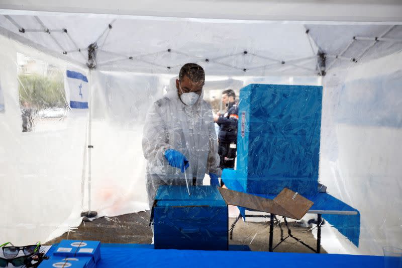 A medic in a protective suit votes in a special polling station set up by Israel's election committee in Ashkelon, Israel