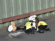 Police officers investigate on the city motorway A100 after an accident in Berlin, Germany, Wednesday, Aug. 19, 2020. The city's highway was still shut down after a series of traffic accidents that were allegedly all caused by one man. (Paul Zinken/dpa via AP)