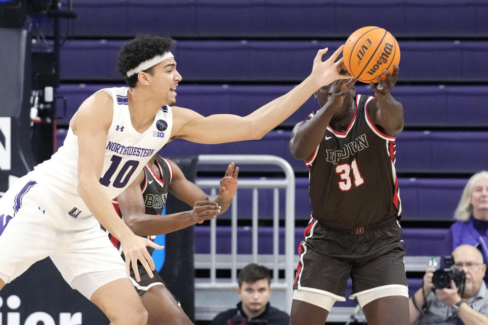 Northwestern forward Tydus Verhoeven, left, and Brown forward Nana Owusu-Anane battle for a loose ball during the first half of an NCAA college basketball game in Evanston, Ill., Thursday, Dec. 29, 2022. (AP Photo/Nam Y. Huh)