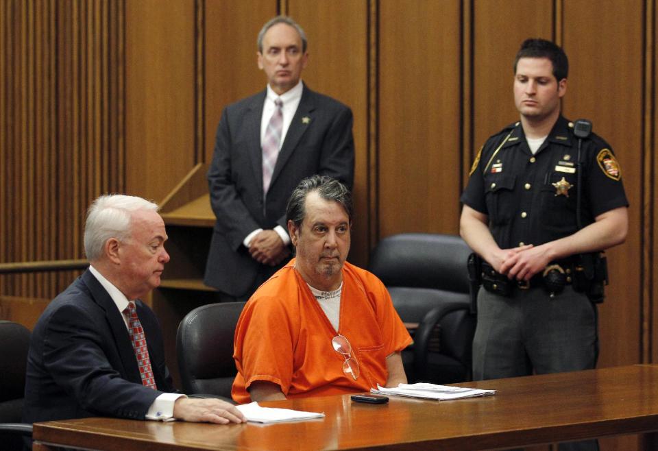 Bobby Thompson, center, sits with his attorney Mark Stanton, left, during his hearing in Cuyahoga County Court in Cleveland on Tuesday, May 8, 2012. Thompson is accused of running a scam that collected millions in donations from people who believed they were helping U.S. Navy veterans. (AP Photo/Amy Sancetta)