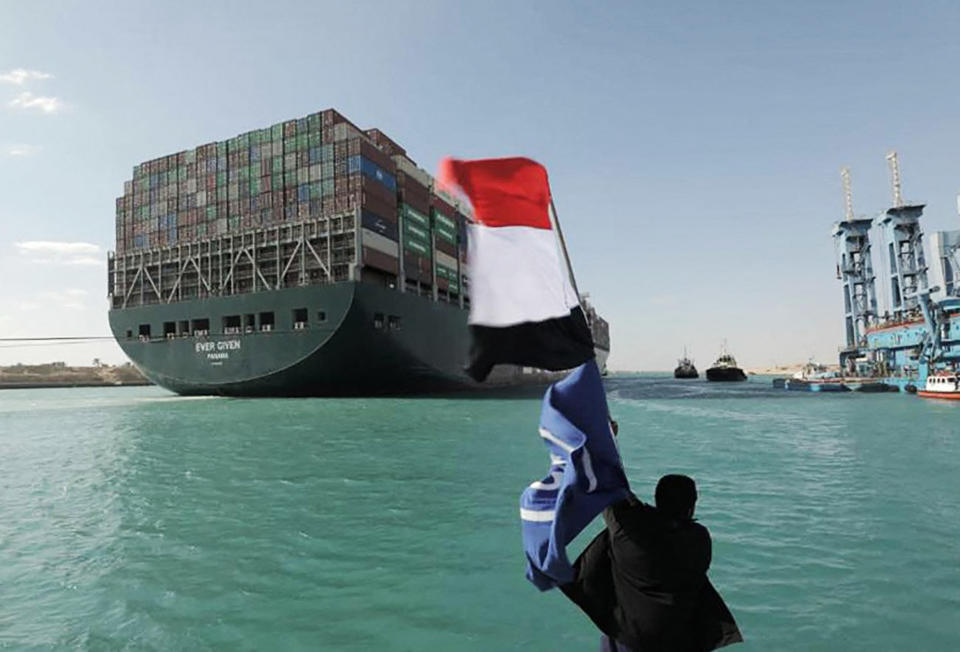 A picture released by Egypt's Suez Canal Authority on March 29, 2021, shows a man waving the Egyptian flag as the Ever Given container ship is dislodged. (AFP - Getty Images)