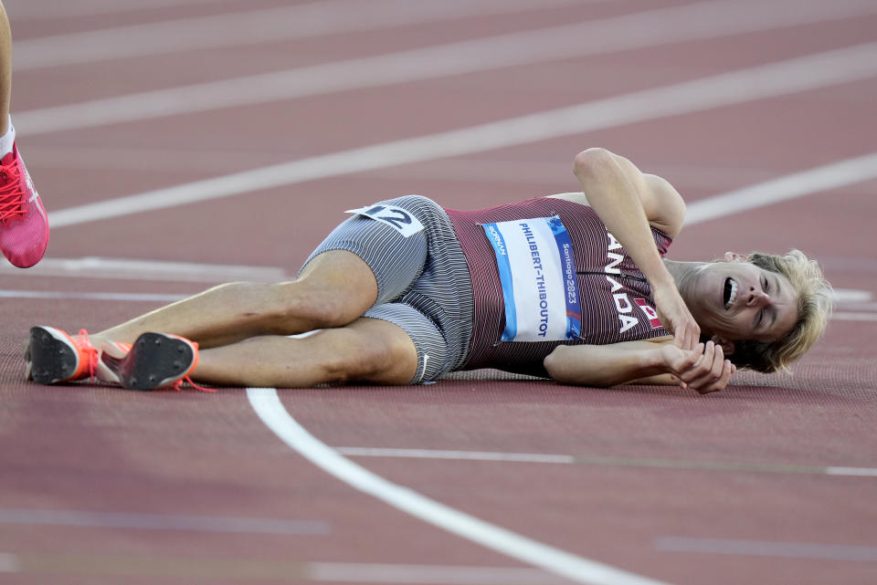Canada's Charles Philibert-Thiboutot lays on the track after his gold medal performance in the men's 1,500-meter final at the Pan American Games in Santiago, Chile, Thursday, Nov. 2, 2023. (Frank Gunn/The Canadian Press via AP)