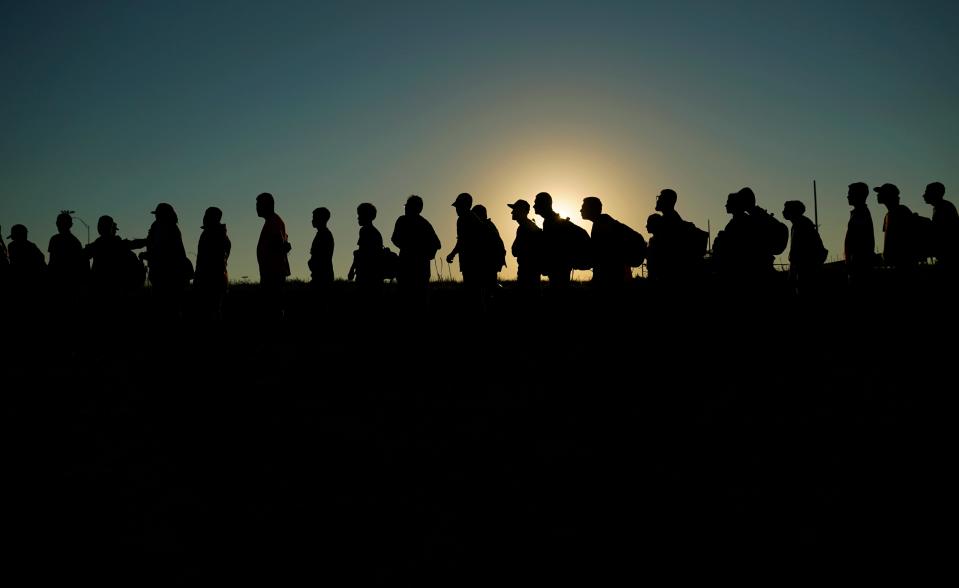 Migrants who crossed the Rio Grande and entered the U.S. from Mexico are lined up for processing by U.S. Customs and Border Protection on Sept. 23, 2023.