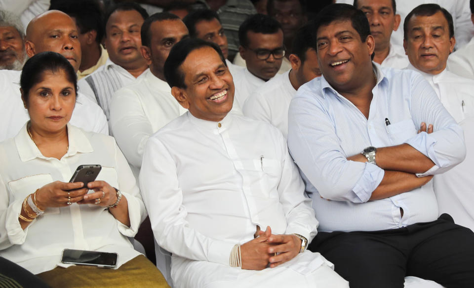 In this Monday, Dec. 23, 2019, photo, former Cabinet minister Rajitha Senaratne, center, sits with colleague Ravi Karunanayake during a protest in Colombo, Sri Lanka. Sri Lankan police arrested the hospitalized former Cabinet minister on Friday, Dec. 27, for alleged involvement in organizing a news conference about abductions under the government of the current president's brother. Lawyer Gunaratna Wanninayake said Senarathna, now an opposition lawmaker, was arrested at a private hospital where he was admitted on Thursday. (AP Photo/Eranga Jayawardena)