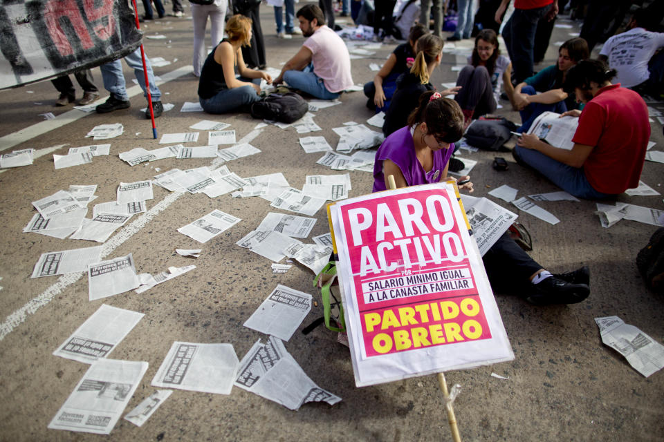 Strikers sit on a main highway with banners that read in Spanish; "Active strike," in Buenos Aires, Argentina, Thursday, April 10, 2014. A nationwide strike has paralyzed Argentina’s public transportation, all non-emergency hospital attention and other sections of public life. Strikers are demanding an increase in salaries to combat inflation, which is expecting to accelerate this year. (AP Photo/Natacha Pisarenko)