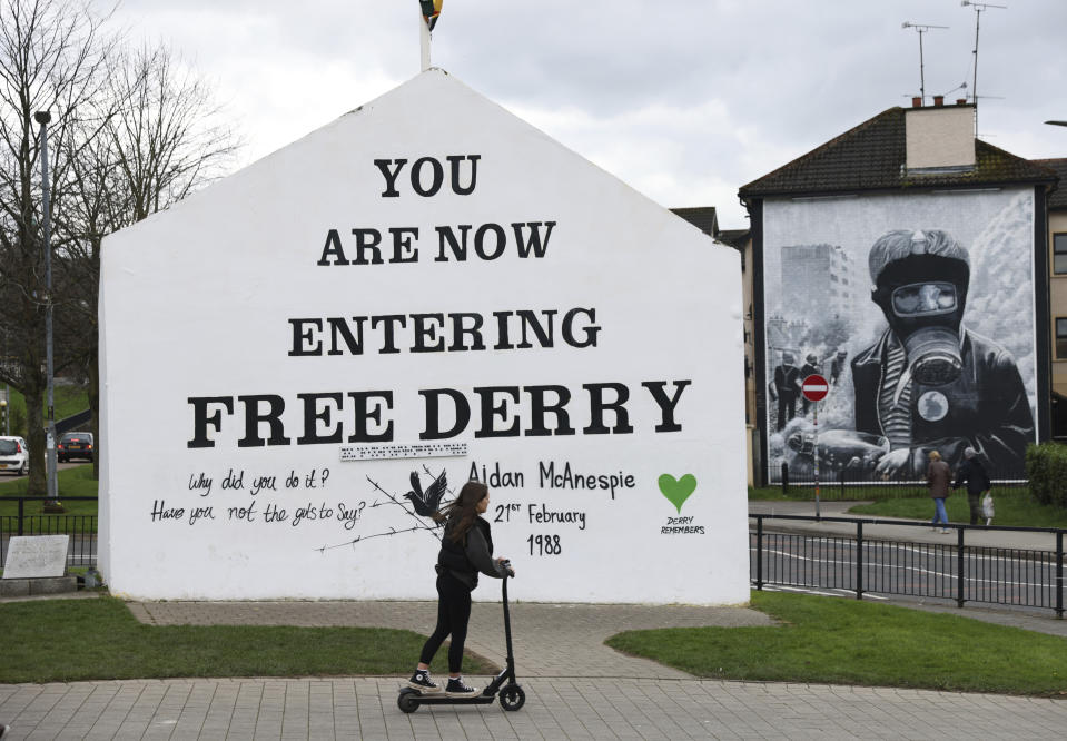 A woman passes Free Derry corner in Londonderry, Northern Ireland, Monday, April 3, 2023. It has been 25 years since the Good Friday Agreement largely ended a conflict in Northern Ireland that left 3,600 people dead. (AP Photo/Peter Morrison)