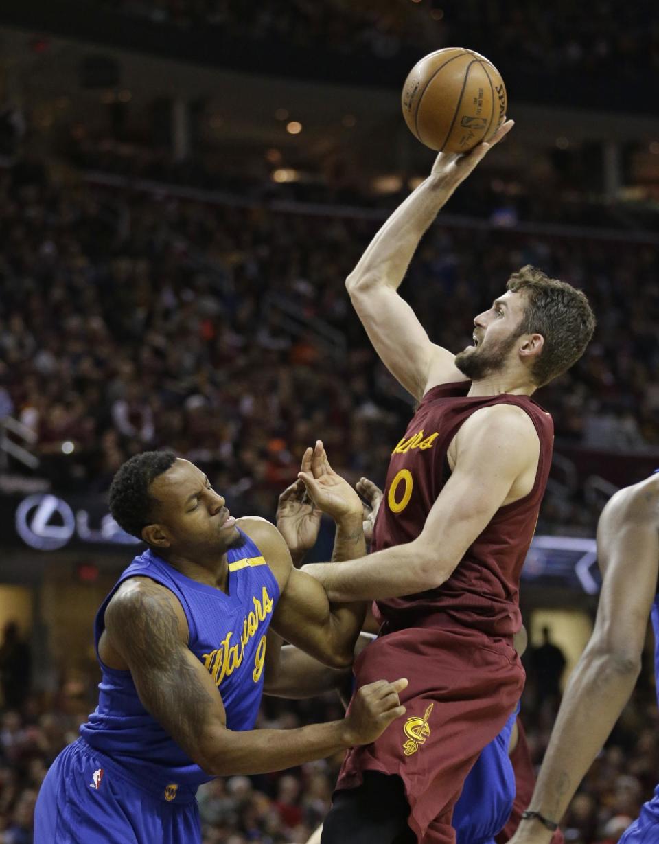 Golden State Warriors' Andre Iguodala, left, fouls Cleveland Cavaliers' Kevin Love in the first half of an NBA basketball game, Sunday, Dec. 25, 2016, in Cleveland. (AP Photo/Tony Dejak)