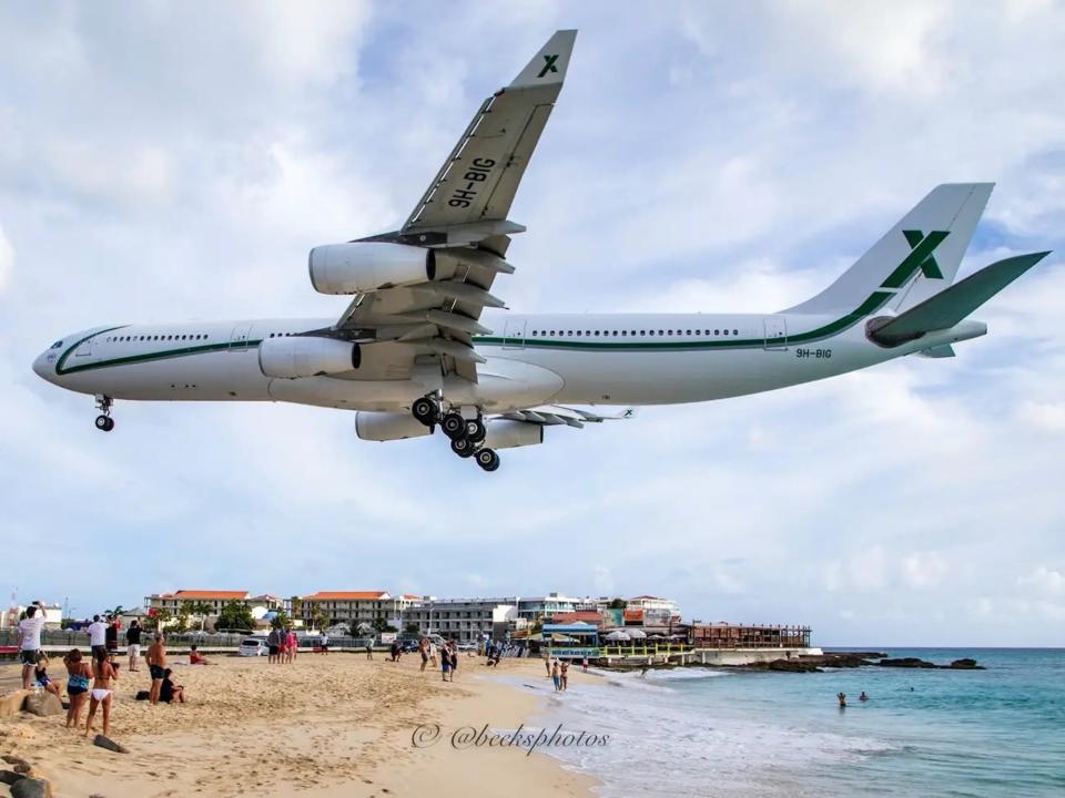 AirX Charters' A340 aircraft with a white fuselage and green stripe.