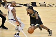 Memphis Grizzlies guard Ja Morant (12) drives against Phoenix Suns guard Jevon Carter (4) in the first half of an NBA basketball game Monday, Jan. 18, 2021, in Memphis, Tenn. (AP Photo/Brandon Dill)