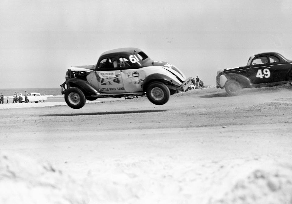 FILE - Red Farmer (61) goes airborne after hitting a hole on the four-mile Daytona Beach road course during the 100-mile Modified and Sportsmen type stock car race in Daytona Beach, Fla., Feb. 14, 1953. NASCAR marks its 75th year in 2023, recalling both its highs and lows. (AP Photo/James P. Kerlin, File)