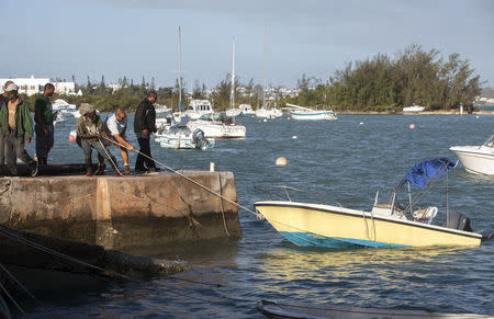 Men try to recover damaged boats after Hurricane Gonzalo passed through in Sandys Parish, western Bermuda, October 18, 2014. REUTERS/Nicola Muirhead