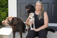 Amy Chadwick poses at her current home with her pets, Monday, April 8, 2024, in Satellite Beach, Fla. Chadwick, a victim of the fires in Hawaii, moved to Florida where she could stretch her homeowners insurance dollars while she waits for her lot to be cleared and for permission to rebuild. (AP Photo/John Raoux)