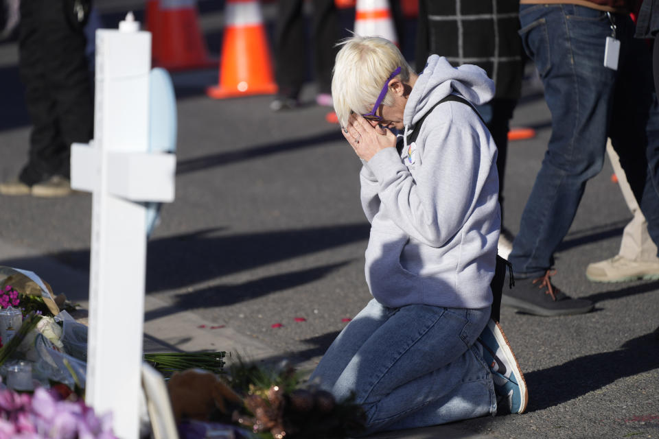 FILE - Dallas Dutka of Broomfield, Colo., prays by a makeshift memorial for the victims of a shooting at a gay nightclub, Nov. 22, 2022, in Colorado Springs, Colo. Dutka's cousin, Daniel Aston, was killed in the shooting. A hearing is scheduled to begin Wednesday, Feb. 22, for Anderson Lee Aldrich in the case. (AP Photo/David Zalubowski, File)