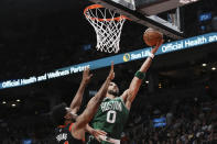 Boston Celtics forward Jayson Tatum (0) goes for the layup as Toronto Raptors forward Thaddeus Young (21) defends during the second half of an NBA basketball game in Toronto, Monday, Dec. 5, 2022. (Chris Young/The Canadian Press via AP)