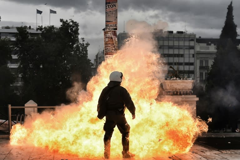 A firebomb explodes beside a riot policeman during a massive protest on February 4, 2016