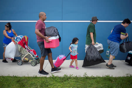 Residents carry their belongings into a shelter ahead of the downfall of Hurricane Irma in Estero, Florida, U.S. September 9, 2017. REUTERS/Adrees Latif