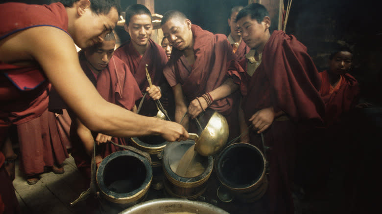 monks serving yak butter tea