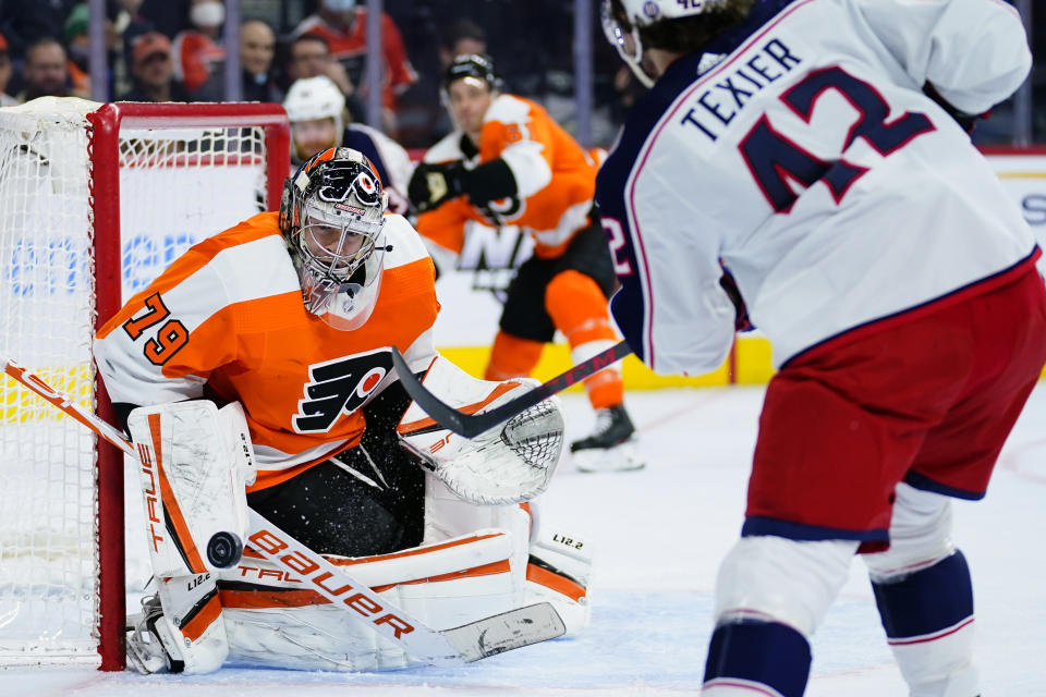 Philadelphia Flyers' Carter Hart, left, blocks a shot by Columbus Blue Jackets' Alexandre Texier during the first period of an NHL hockey game, Thursday, Jan. 20, 2022, in Philadelphia. (AP Photo/Matt Slocum)